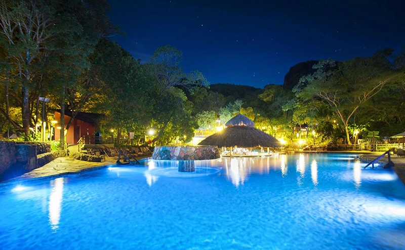 Piscina de águas termais iluminada à noite no complexo de Rio Quente, em Goiás
